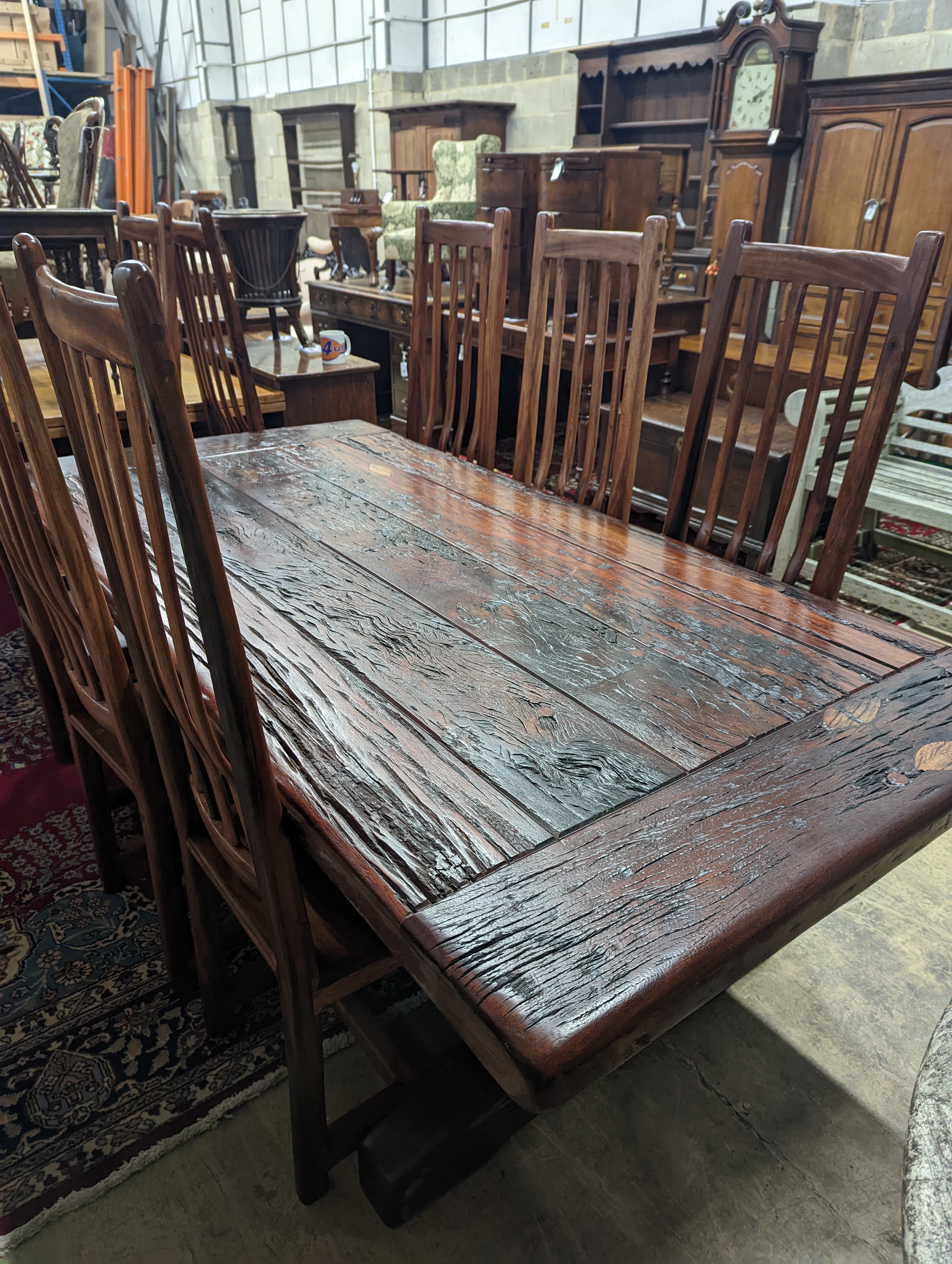 A South African distressed hardwood rectangular refectory dining table, length 200cm, depth 100cm, height 75cm and eight hardwood high back wood seat dining chairs